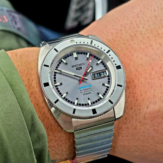 Watches and More_Seiko 5 Sports automatico con quadrante grigio e bracciale in acciaio.