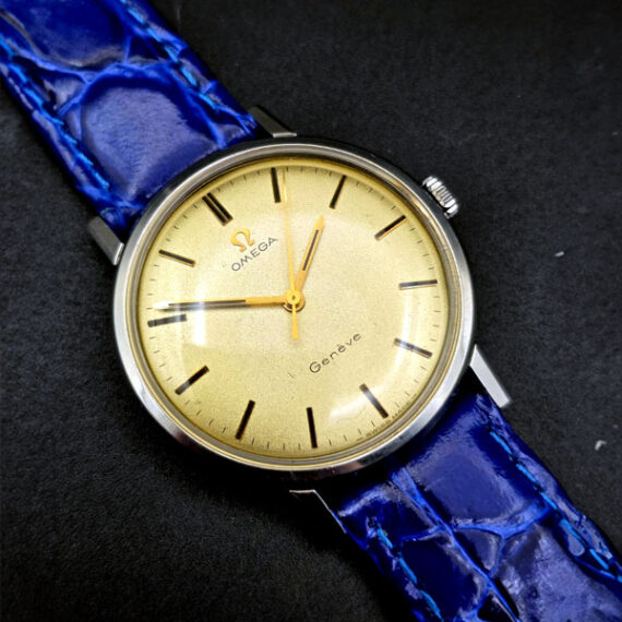 Watches And More_Omega Genève con quadrante dorato e cinturino in pelle blu.
